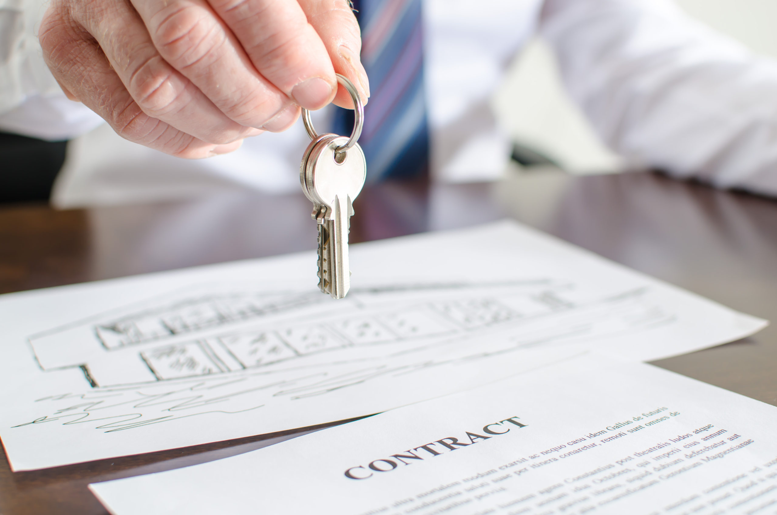 Real Estate Transaction Lawyers with Real Estate Agent Giving Keys